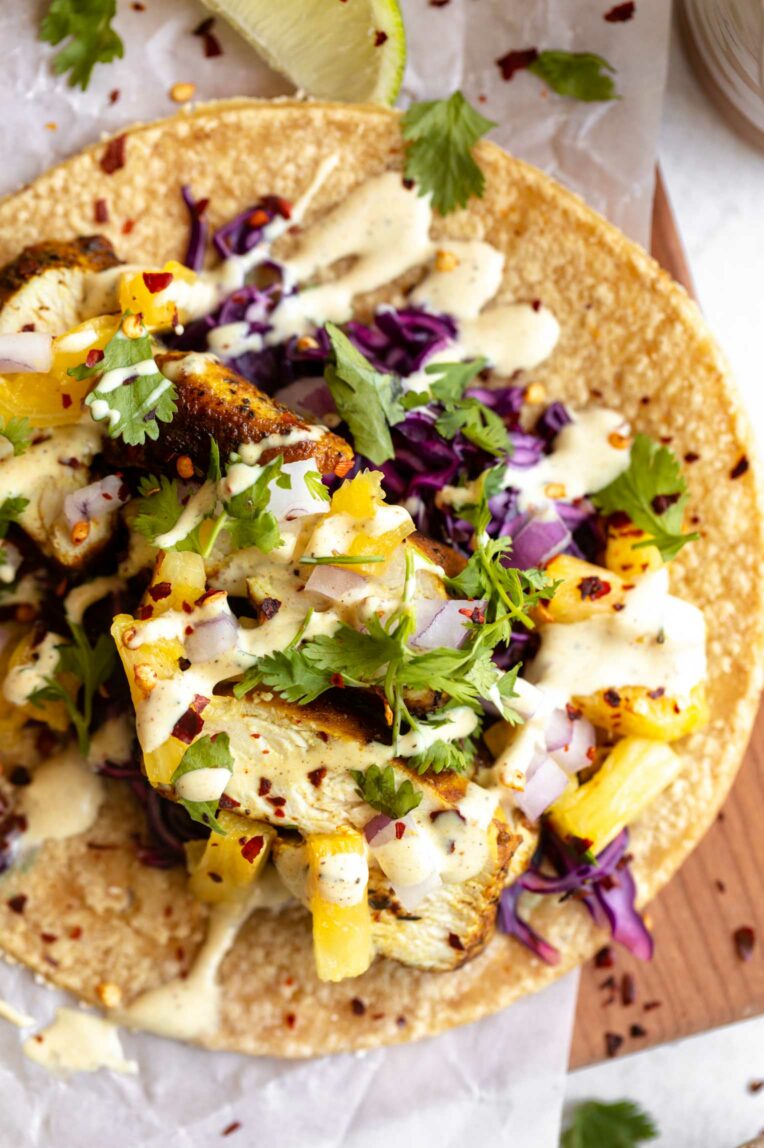 Jerk Chicken Tacos w/ Mango Avocado Salsa on a grey napkin.
