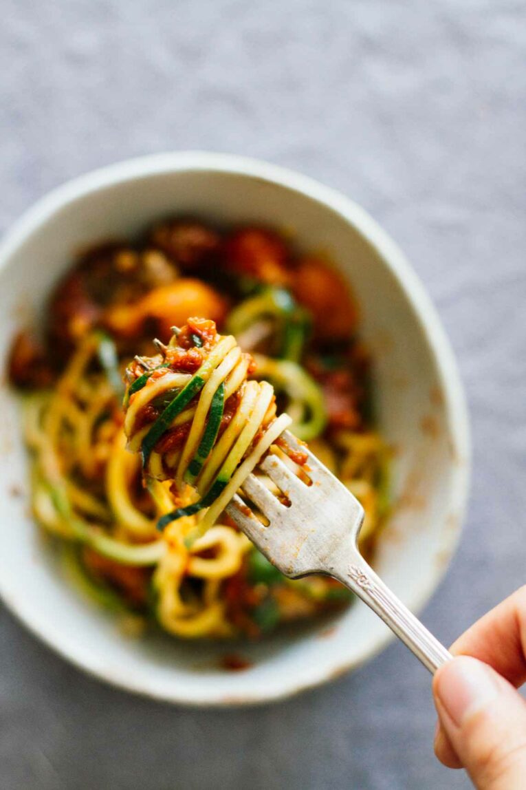 Vegetarian Zucchini Spaghetti w/ Red Sauce & Mushrooms twisted up on a fork