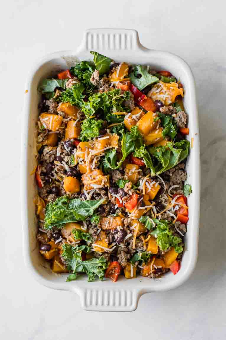 Beans, kale, peppers, ground beef, and butternut squash in a casserole dish.