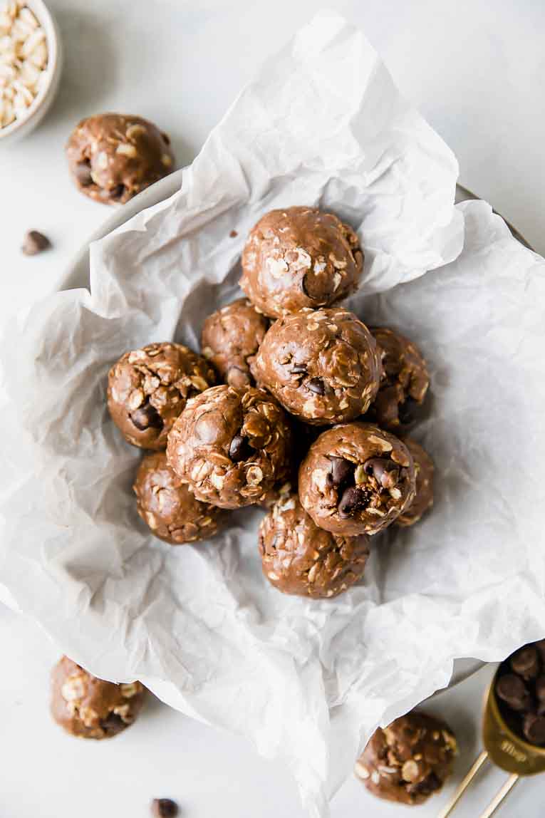 Chocolate Peanut Butter Protein Balls in a bowl with protein balls on counter.