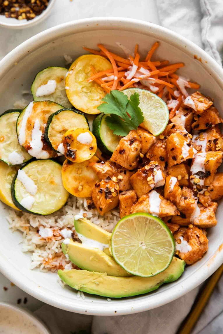 Hot Honey Chicken in a bowl with zucchini, squash, and carrots.