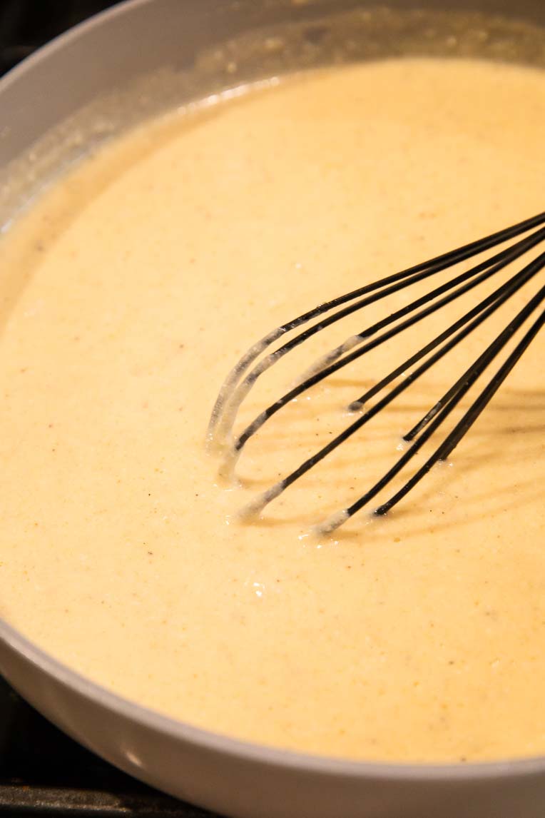 Creamy sauce being mixed together in a sauce pan.