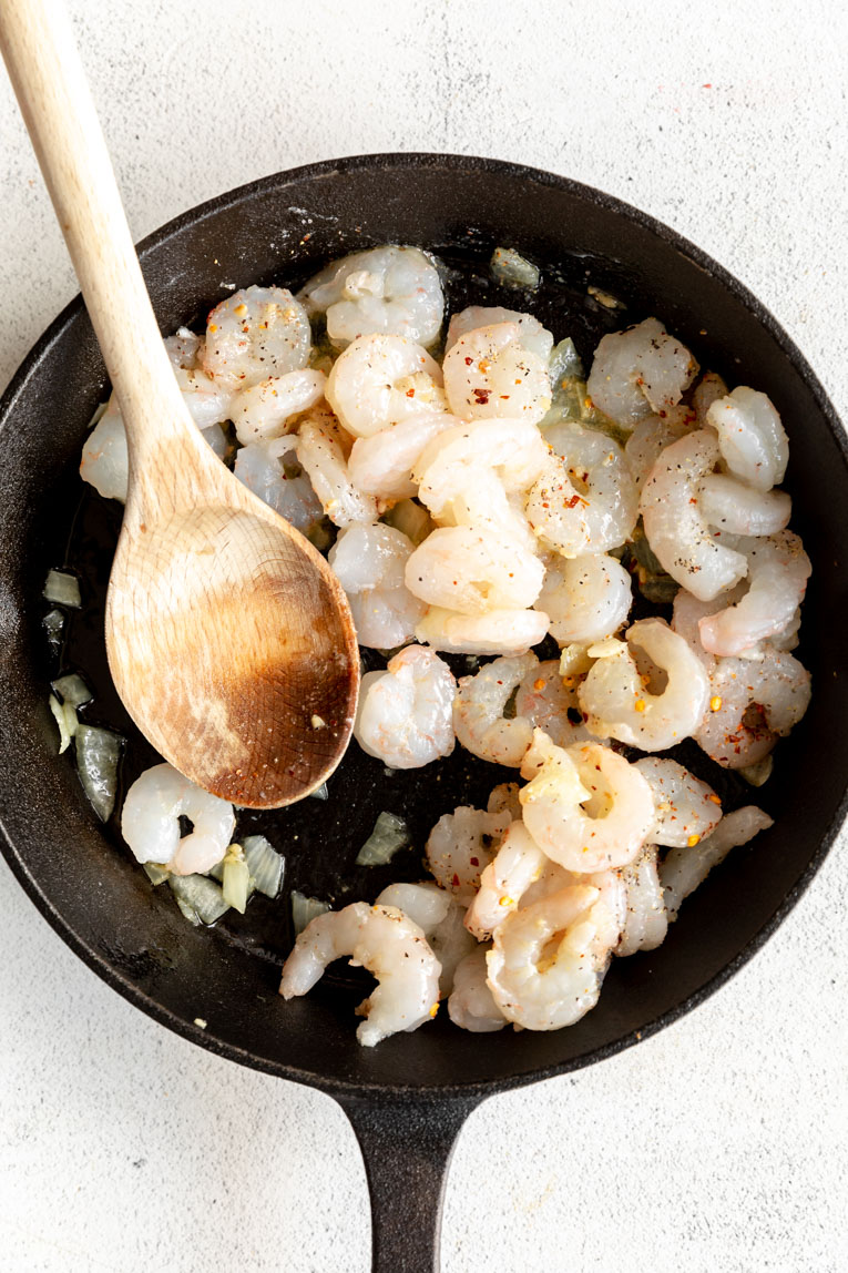 Shrimp being cooked in a cast iron skillet.