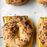 Close up of Meal Prep Breakfast Egg Bagel sandwiches on a baking sheet.