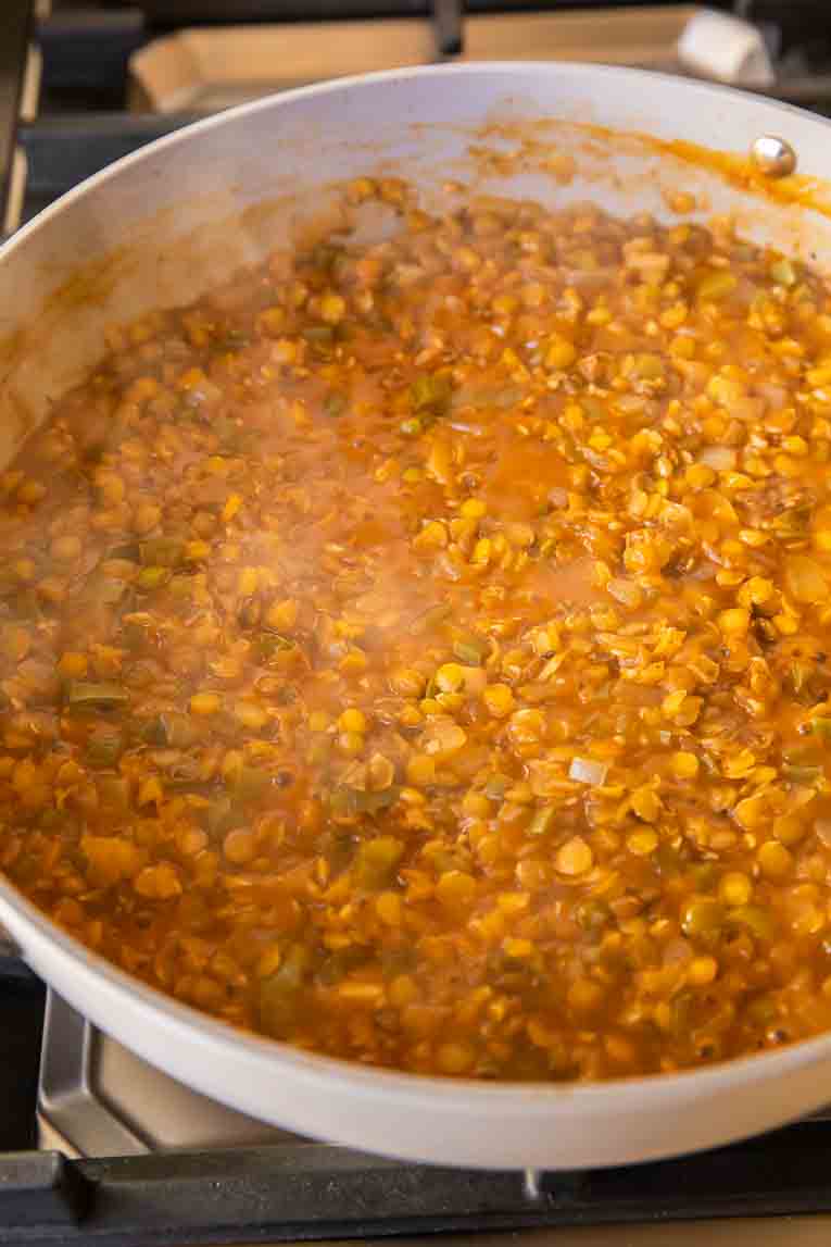 Broth and lentils added to veggie mixture in non-stick pan.