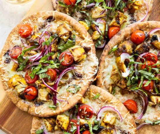 Mediterranean Chicken pizzas on a cutting board.