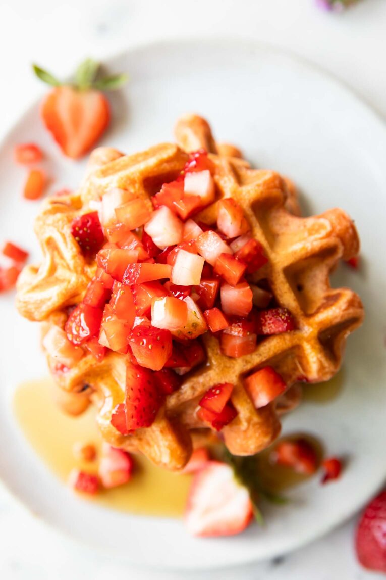 Top view of waffles on a plate with strawberries.