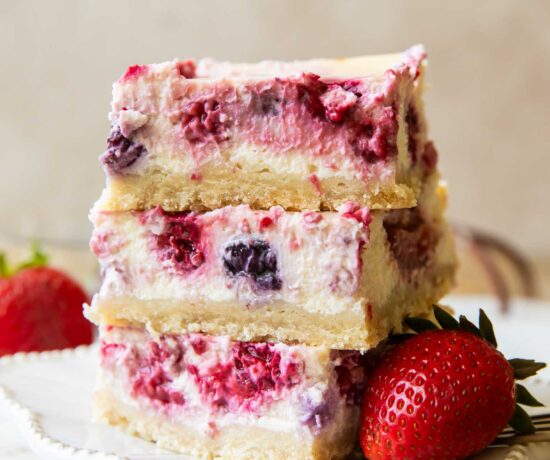 Greek Yogurt Cheesecake bars stacked on top of each other.