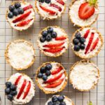 Patriotic fruit tarts on a cooling rack.