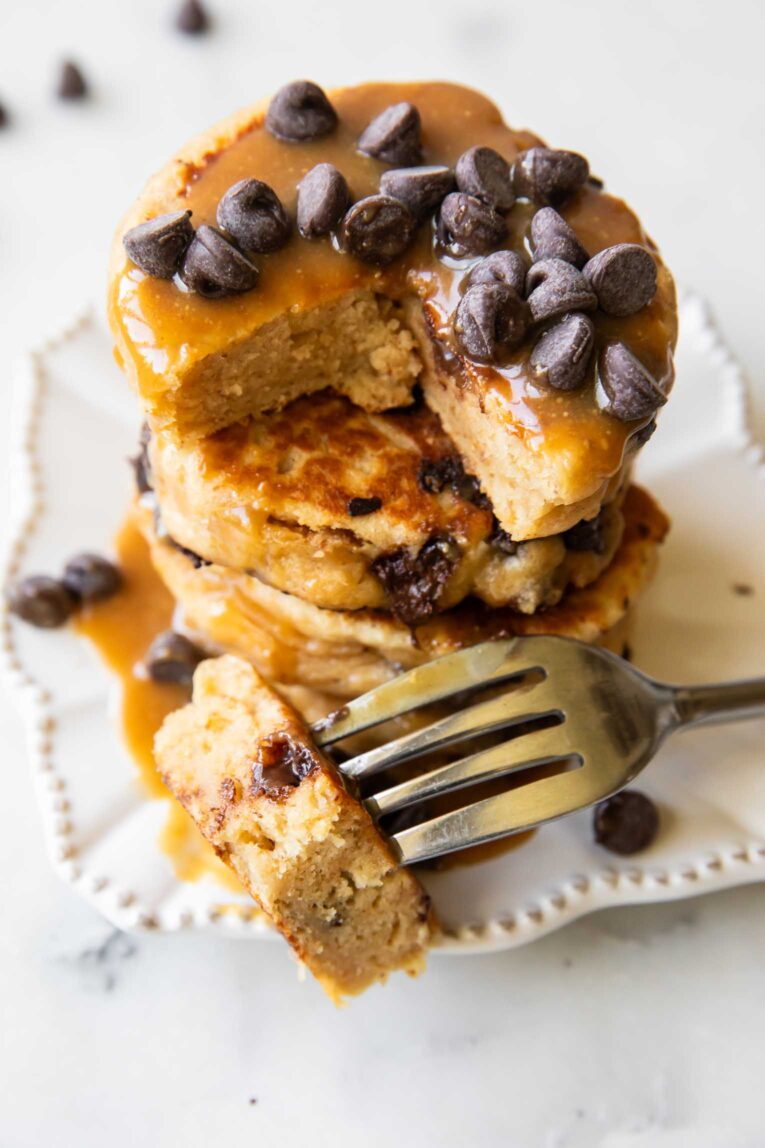 A stack of Peanut Butter Chocolate Chip Pancakes on a plate with a fork.